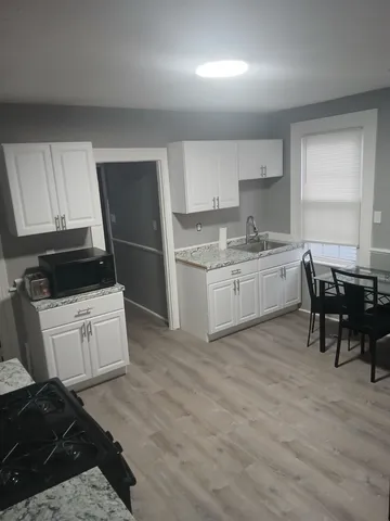 a kitchen with a sink stove and white cabinets