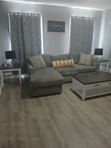 a view of an empty room with wooden floor