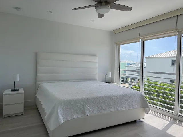 a bedroom with a large bed and a chandelier fan