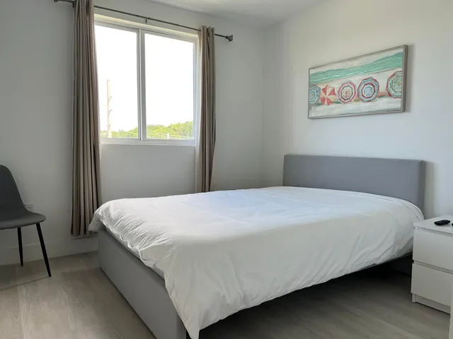 a bedroom with a bed and a painting on the wall