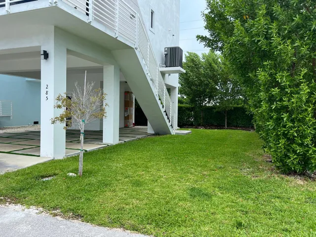 a view of an house with backyard and a tree
