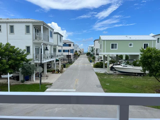 a view of a patio with couches and table and chairs with wooden floor and fence