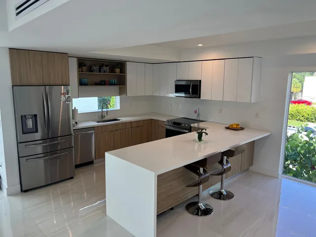 a kitchen with stainless steel appliances a stove a sink and a refrigerator