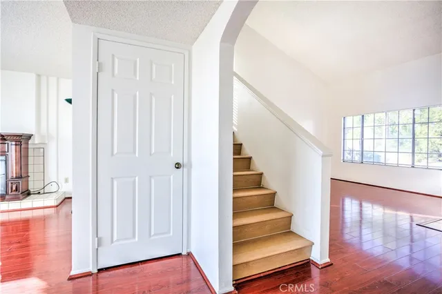 a view of a hallway with wooden floor and staircase