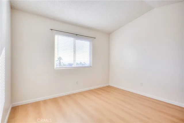 a view of an empty room with closet and a window