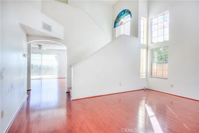 an empty room with windows and wooden floor