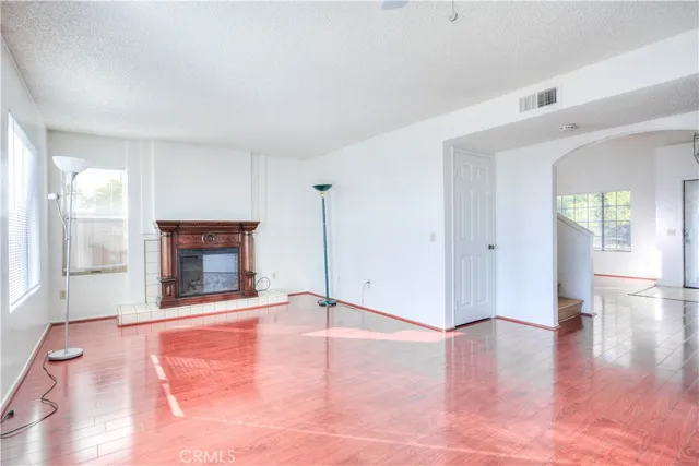 a view of an empty room with window and fire place
