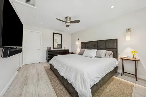 a bedroom with a bed and a flat screen tv