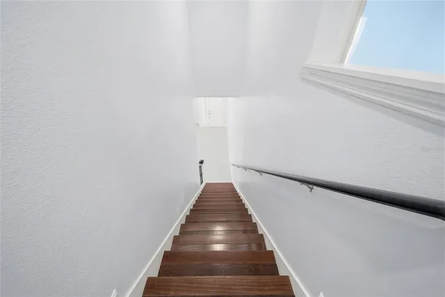 an empty room with windows and ceiling fan