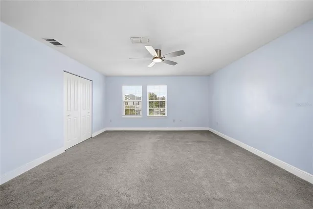 a view of a livingroom with a ceiling fan and window