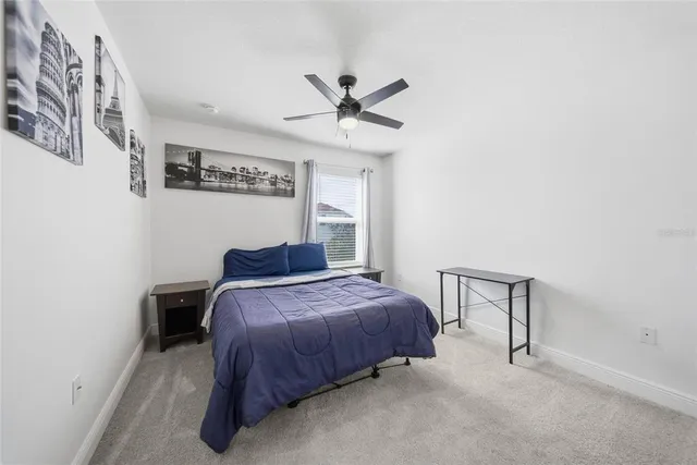 a bedroom with a bed and a ceiling fan