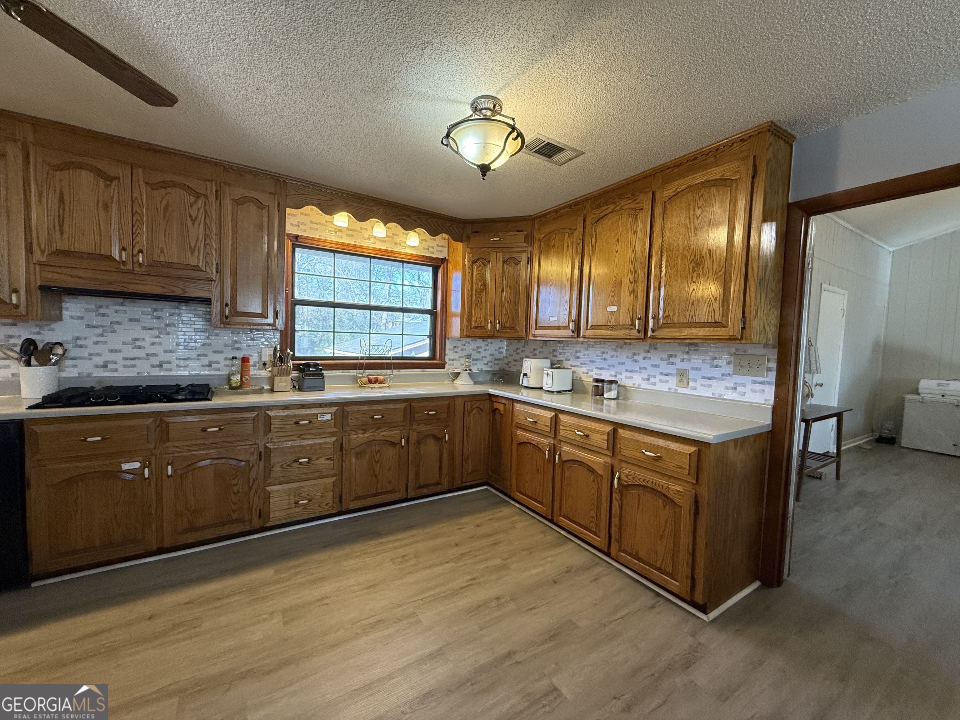 102 Hemlock Street Warner Robins, GA 31093 - Photo 8 of 32 a kitchen with stainless steel appliances granite countertop wooden cabinets a sink and dishwasher with wooden floor