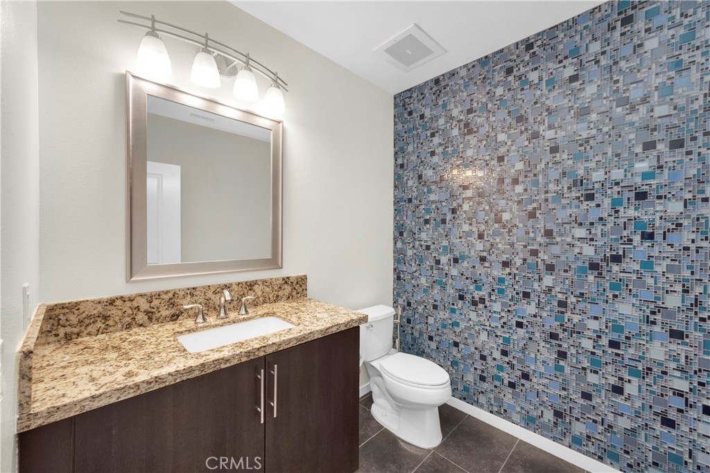 21 Gramercy, Unit 220 Irvine, CA 92612 - Photo 21 of 43 a bathroom with a granite countertop sink a toilet and a mirror