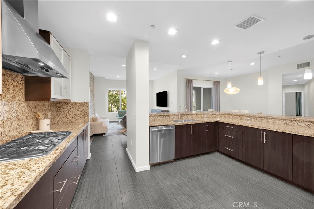 21 Gramercy, Unit 220 Irvine, CA 92612 - Photo 9 of 43 a large kitchen with a large counter top a sink stainless steel appliances and cabinets