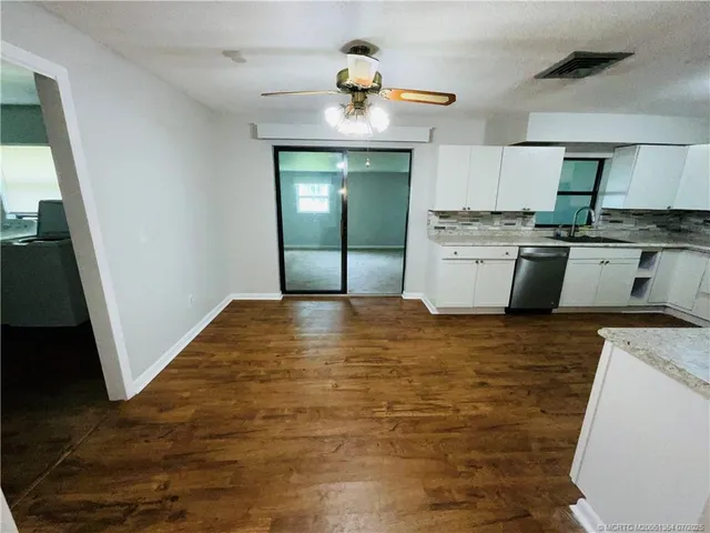 a kitchen with white cabinets stainless steel appliances and sink