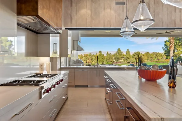 a kitchen with stainless steel appliances a sink a stove and a wooden floor
