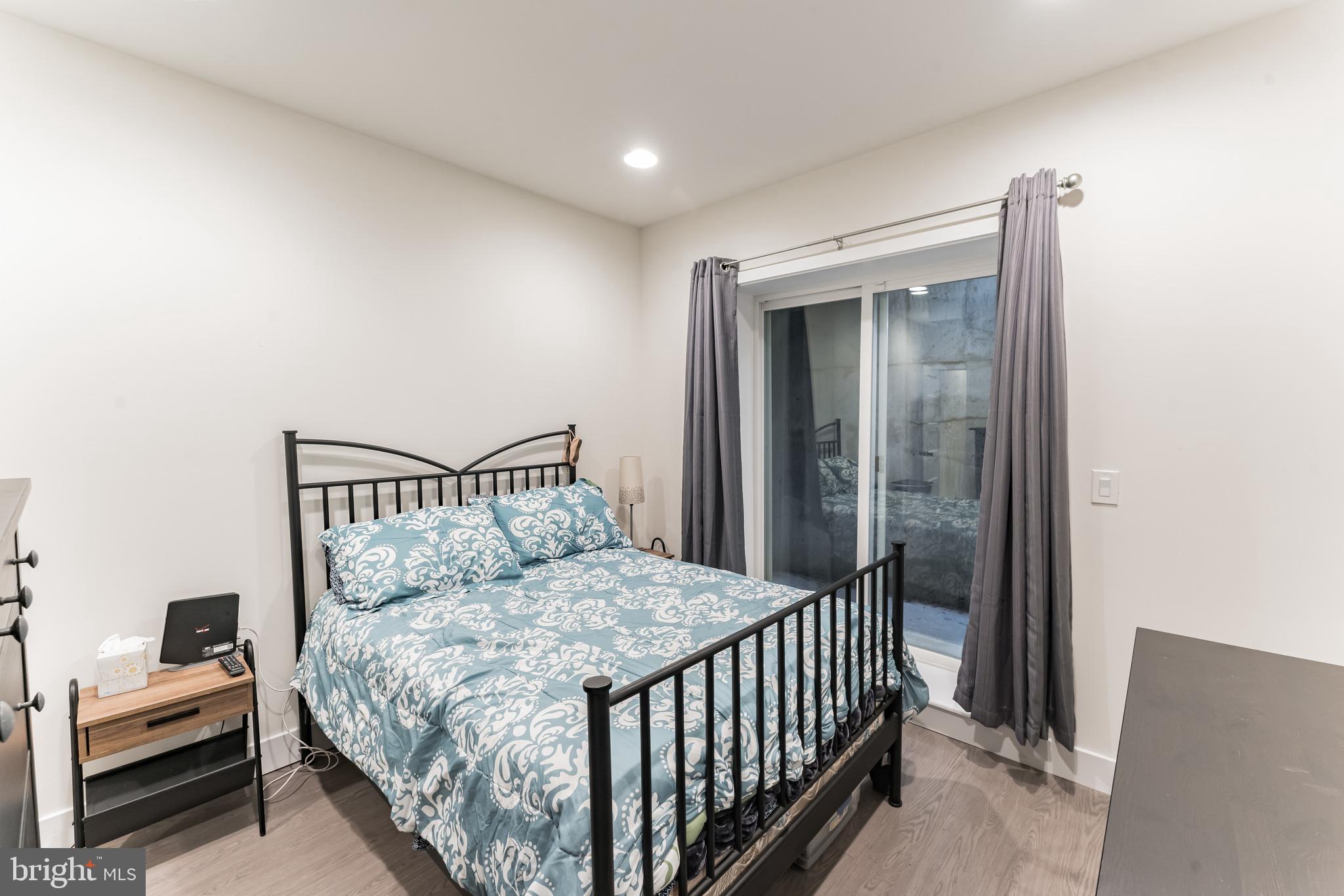 614 Master Street, Unit 1 Philadelphia, PA 19122 - Photo 17 of 28 a bedroom with a bed and a night stand