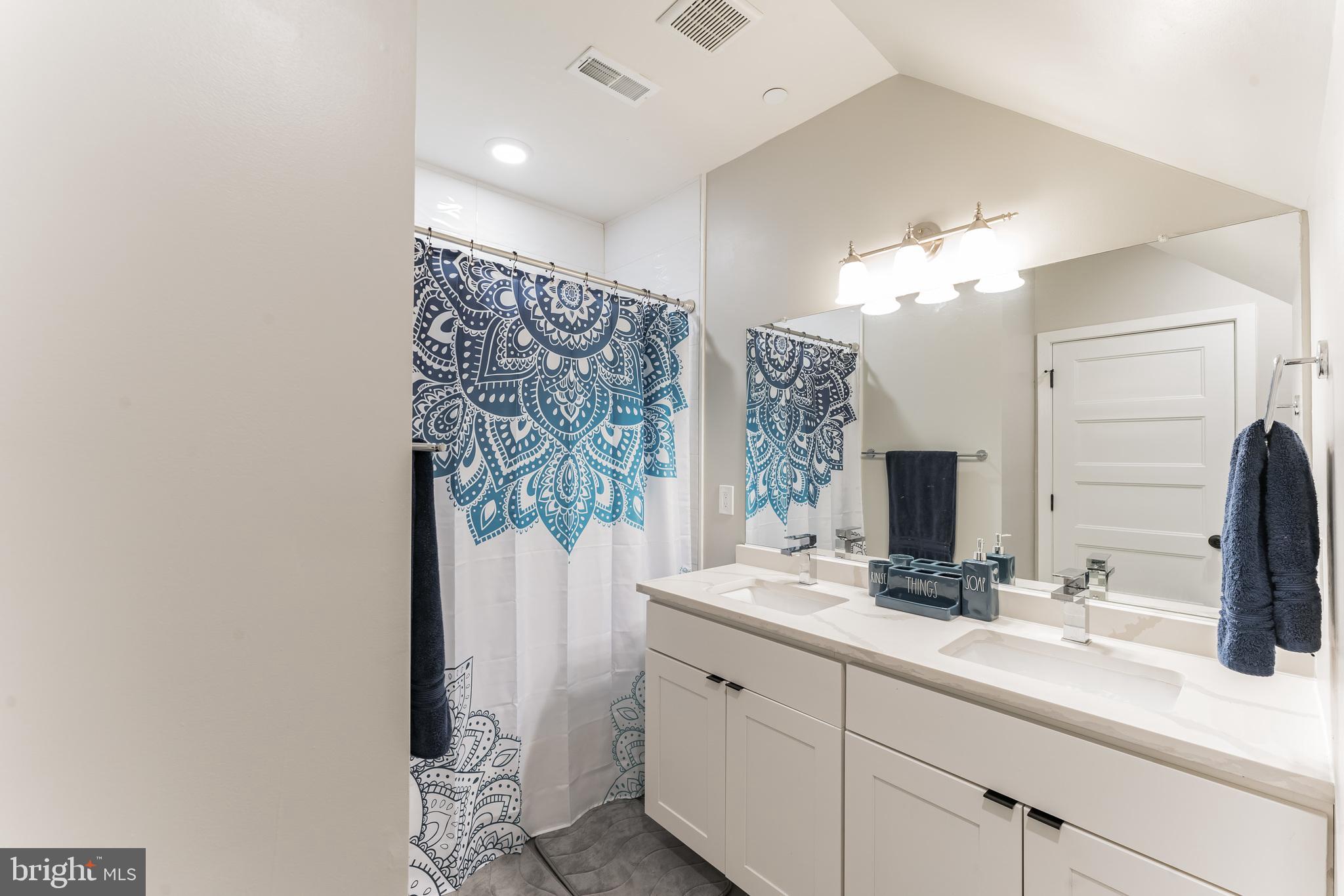 614 Master Street, Unit 1 Philadelphia, PA 19122 - Photo 18 of 28 a bathroom with a double vanity sink and a mirror