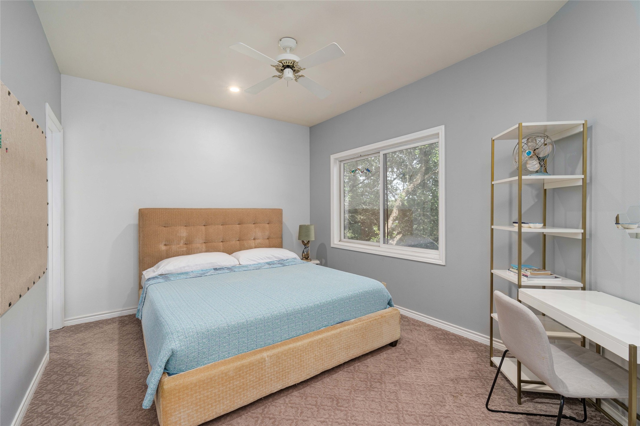 2102 Paisano Road Austin, TX 78746 - Photo 17 of 26 Bedroom featuring a ceiling fan and light carpet