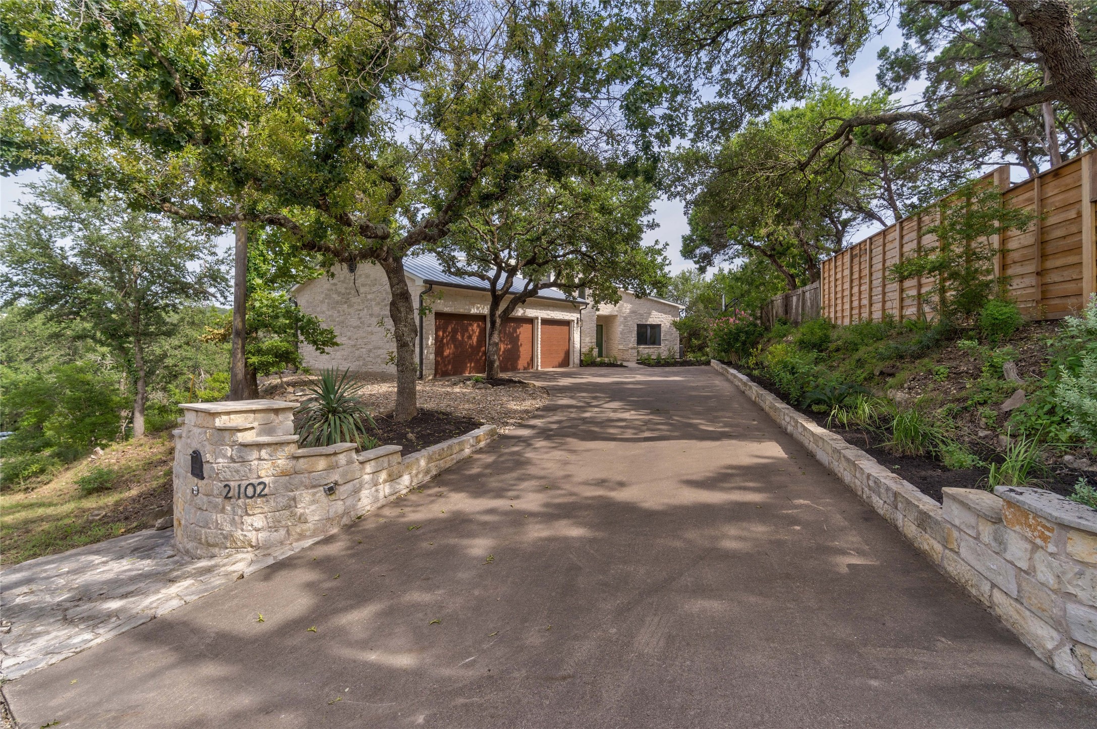 2102 Paisano Road Austin, TX 78746 - Photo 4 of 26 View of front of home with a garage and driveway