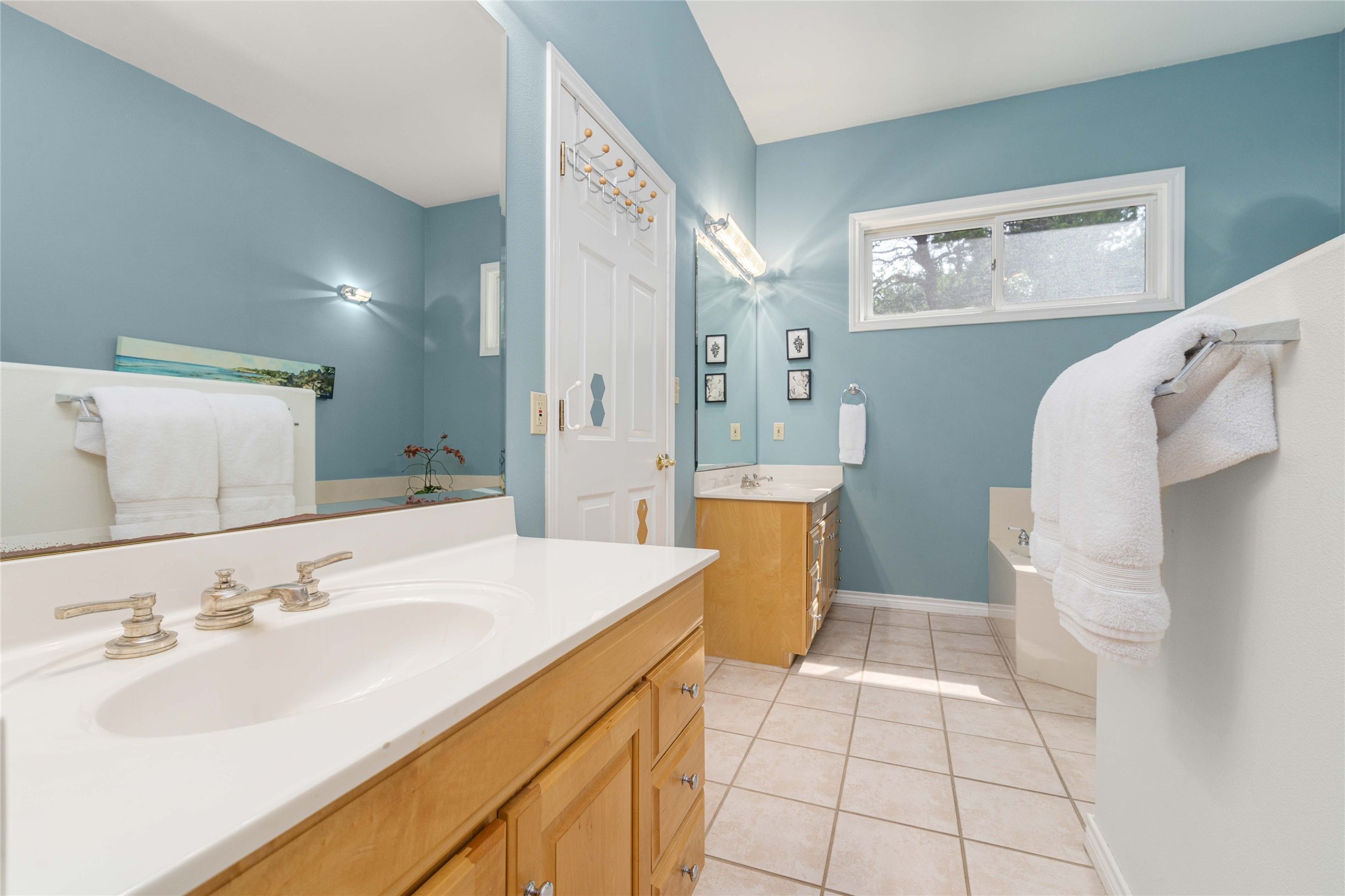 2102 Paisano Road Austin, TX 78746 - Photo 9 of 26 Full bath with two vanities, light tile patterned floors, and a garden tub