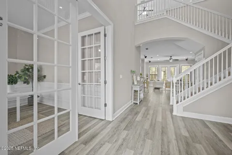 a dining room with furniture a chandelier and wooden floor