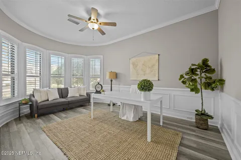 a view of a dining room with furniture a chandelier and wooden floor