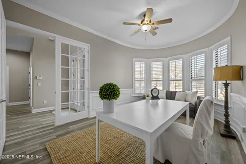 a dining room with furniture a chandelier and wooden floor
