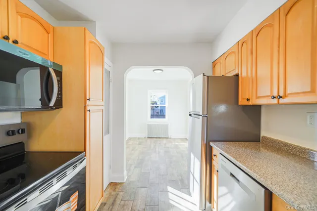 a kitchen with stainless steel appliances granite countertop a refrigerator and a stove