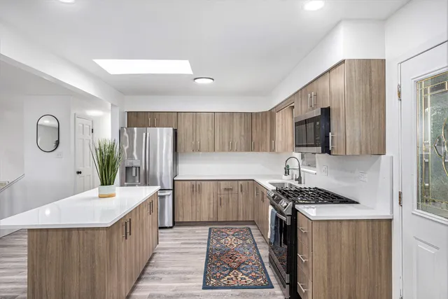 a kitchen with stainless steel appliances a sink dishwasher stove refrigerator and microwave