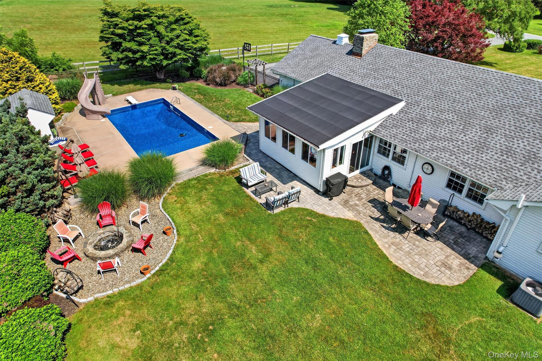 5 Hedges Road Warwick, NY 10990 - Photo 48 of 48 An aerial view of the backyard retreat, showcasing the inground pool with new liner, three-season sunroom, multiple patio areas, firepit, and level lawn designed for everyday enjoyment and outdoor entertaining. An incredible place to call home!