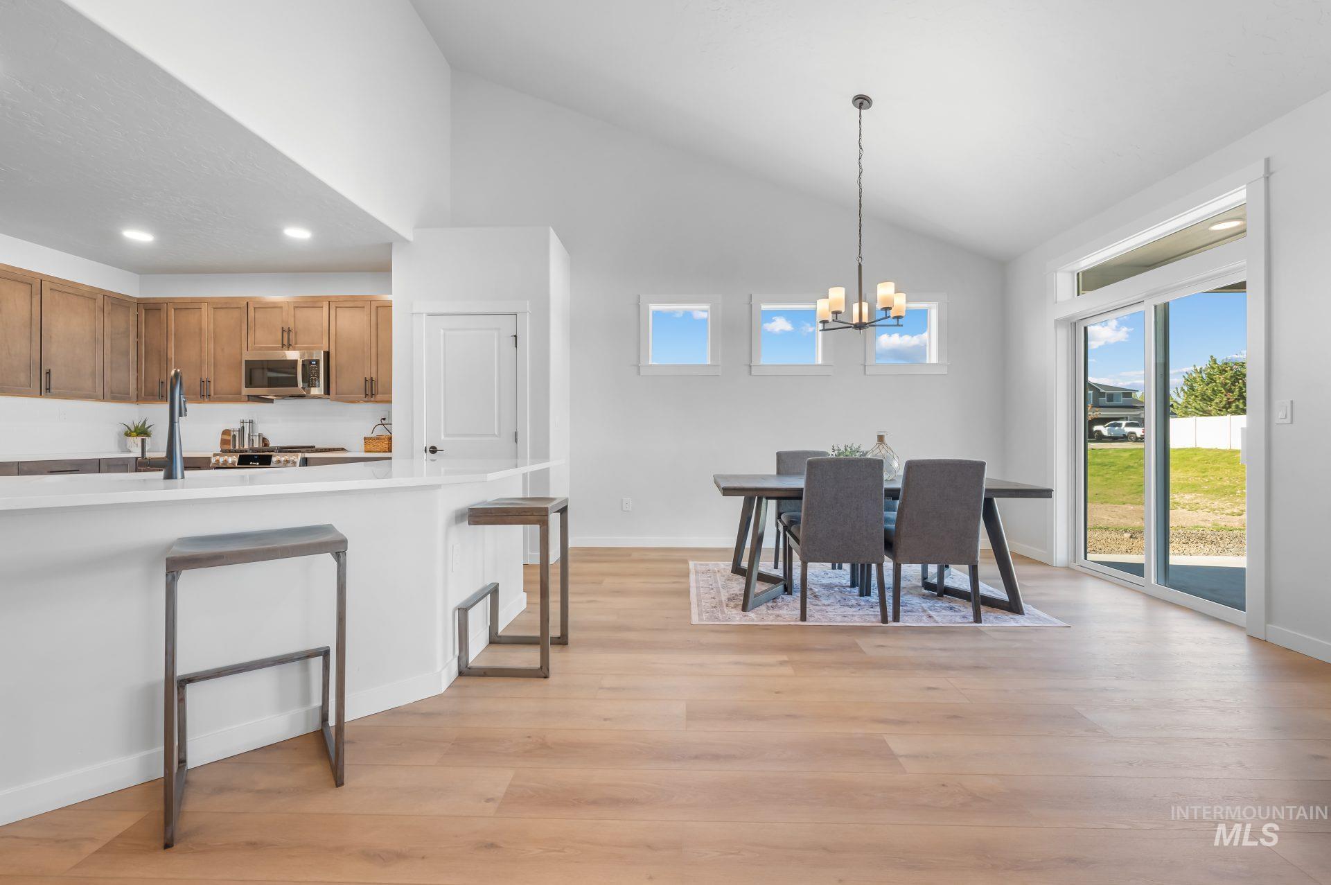 3347 East Fitz Roy Street Kuna, ID 83634 - Photo 4 of 15 Dining room featuring high vaulted ceiling, light wood-style floors, a chandelier, and recessed lighting