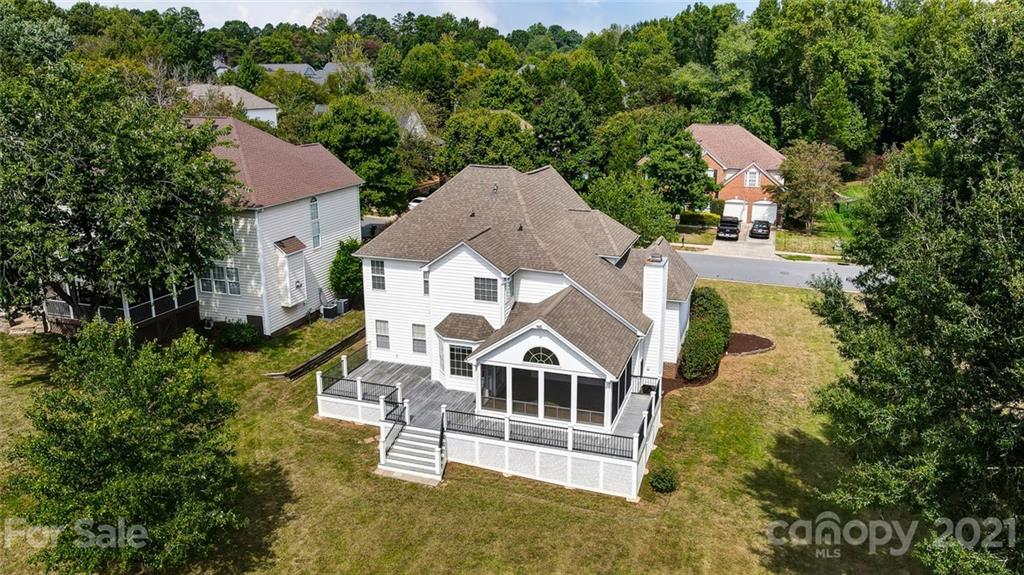 an aerial view of a house with a big yard and large trees