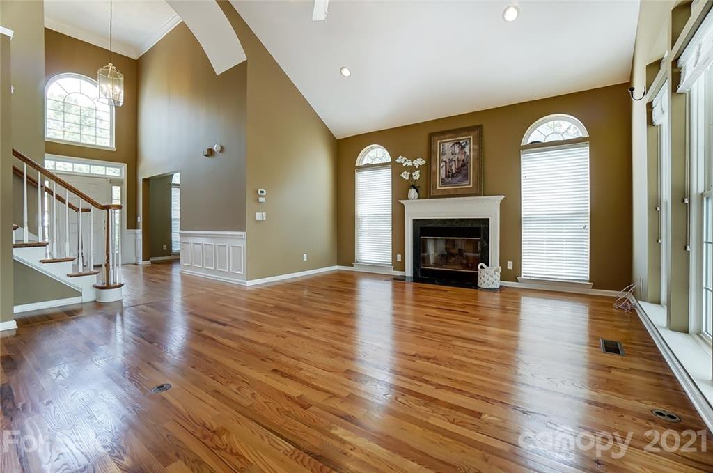15922 Hollingbourne Road Huntersville, NC 28078 - Photo 11 of 48 an empty room with wooden floor fireplace and windows