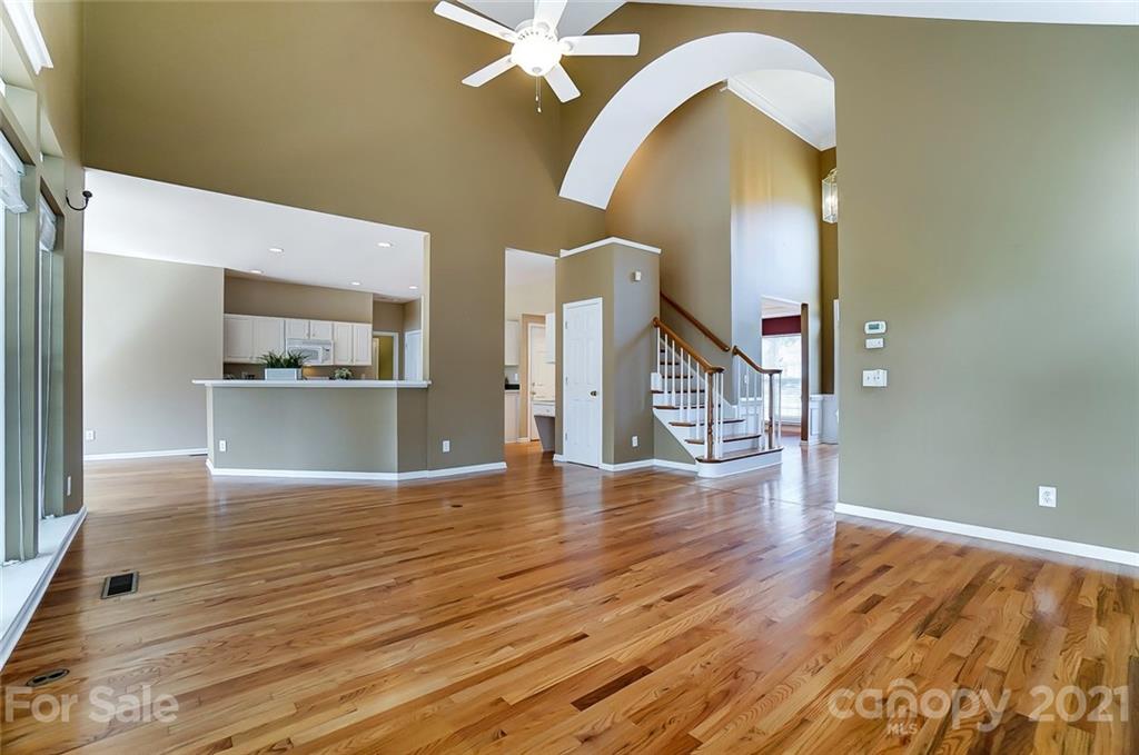 15922 Hollingbourne Road Huntersville, NC 28078 - Photo 12 of 48 a view of empty room with wooden floor and kitchen view
