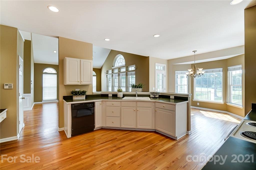 15922 Hollingbourne Road Huntersville, NC 28078 - Photo 20 of 48 a large kitchen with stainless steel appliances granite countertop a stove and a wooden floors