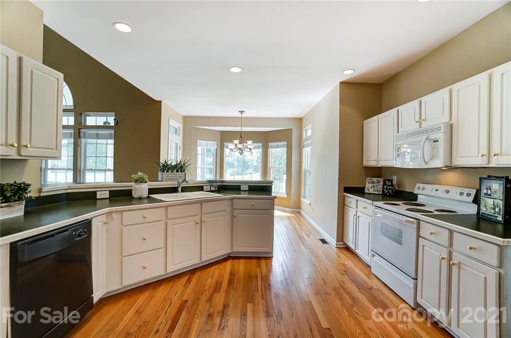 15922 Hollingbourne Road Huntersville, NC 28078 - Photo 21 of 48 a large kitchen with stainless steel appliances granite countertop a lot of counter space and wooden floors