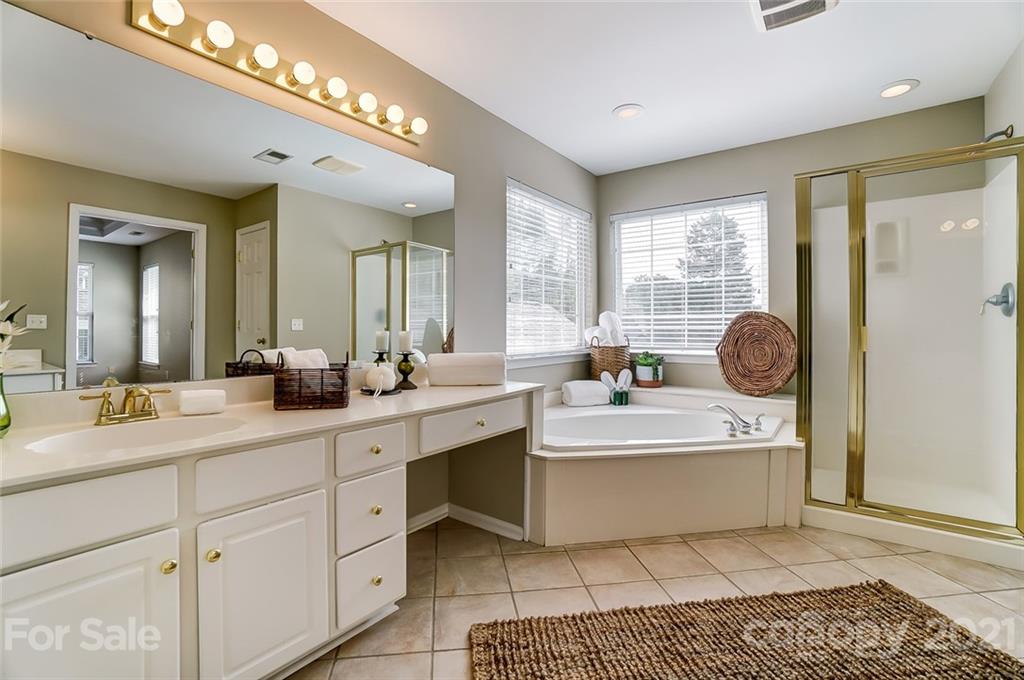15922 Hollingbourne Road Huntersville, NC 28078 - Photo 31 of 48 a spacious bathroom with a double vanity sink a mirror and a bathtub
