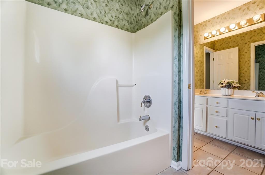 15922 Hollingbourne Road Huntersville, NC 28078 - Photo 36 of 48 a bathroom with a bathtub a sink a vanity and a shower