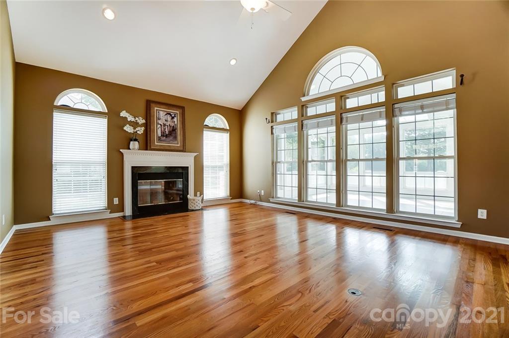 15922 Hollingbourne Road Huntersville, NC 28078 - Photo 9 of 48 a view of an empty room with wooden floor and a fireplace