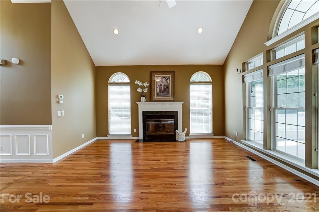 15922 Hollingbourne Road Huntersville, NC 28078 - Photo 10 of 48 a view of an empty room with wooden floor fireplace and a window
