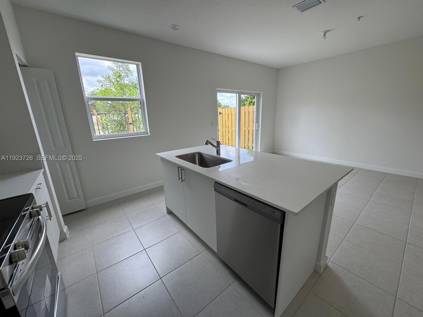 18406 Southwest 2nd Street Pembroke Pines, FL 33029 - Photo 10 of 15 a kitchen with a sink a counter top space and cabinets