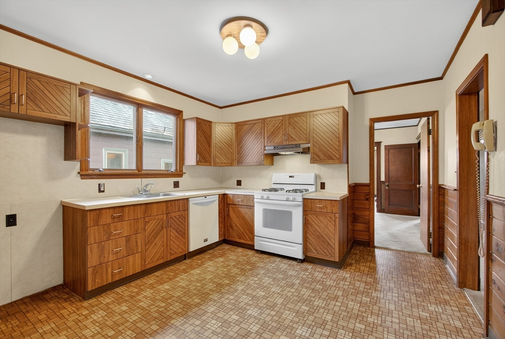 67 Irving Street Somerville, MA 02144 - Photo 25 of 40 a large kitchen with stainless steel appliances granite countertop a stove a sink and a refrigerator