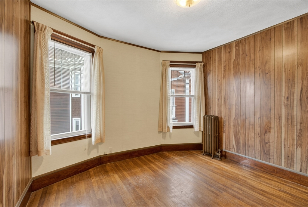 67 Irving Street Somerville, MA 02144 - Photo 30 of 40 an empty room with wooden floor and windows
