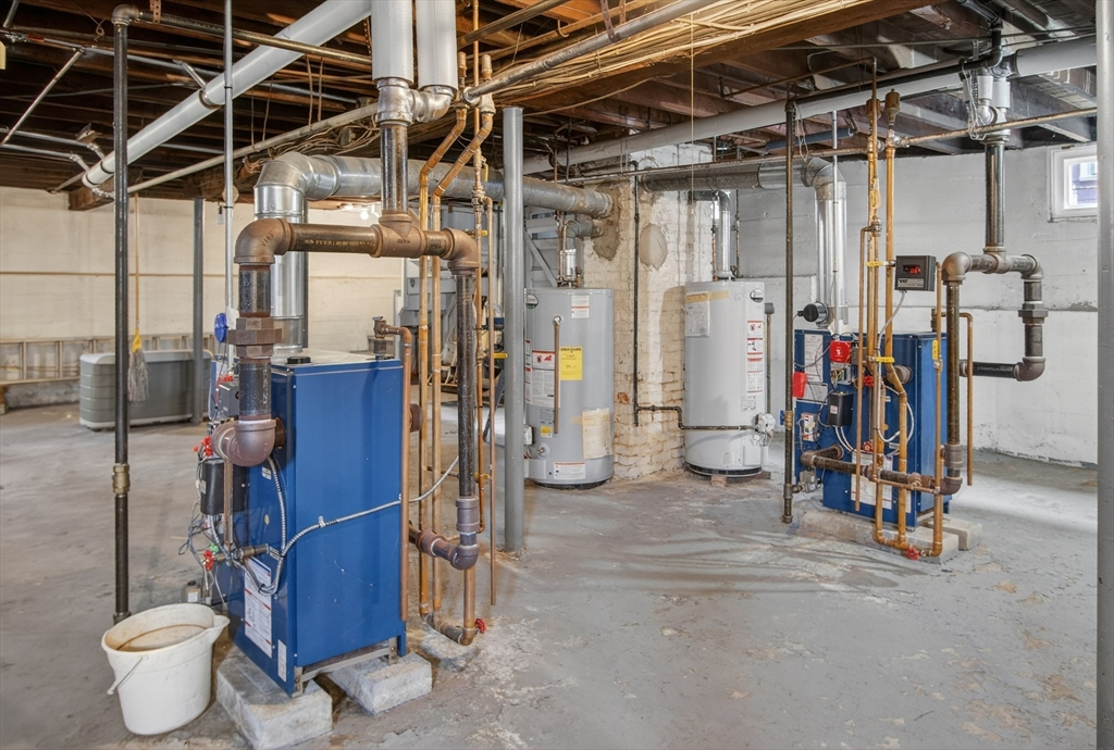 67 Irving Street Somerville, MA 02144 - Photo 33 of 40 a view of a storage room with water heater and racks