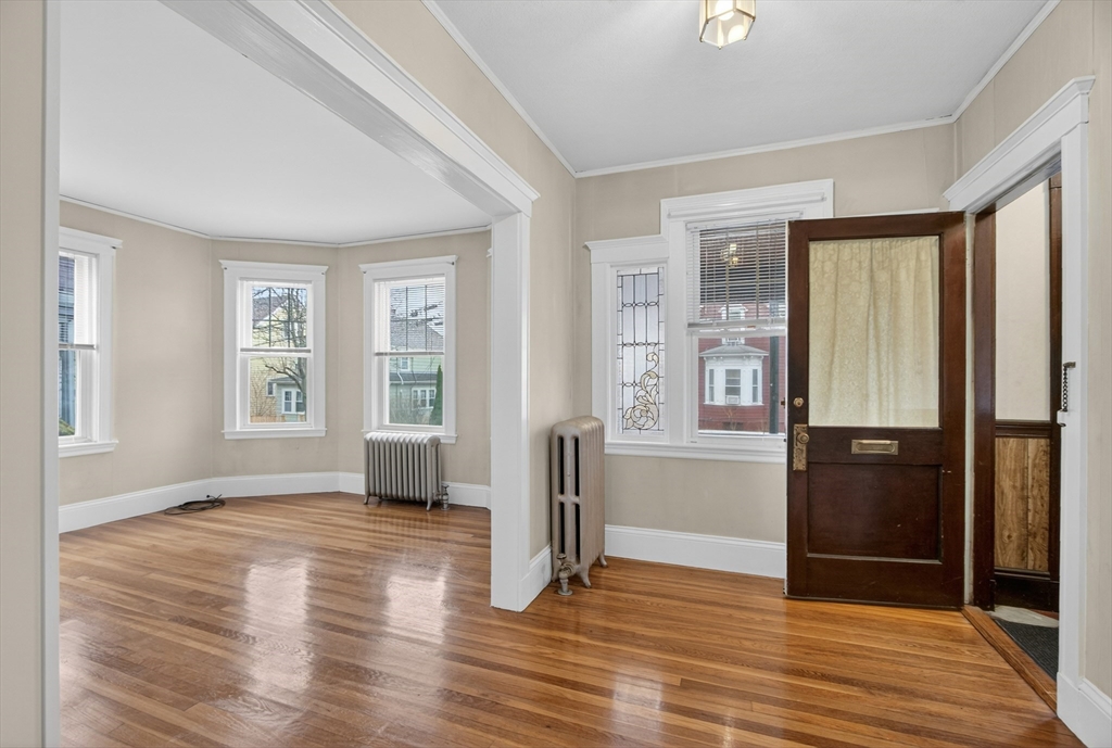 67 Irving Street Somerville, MA 02144 - Photo 5 of 40 an empty room with wooden floor and windows