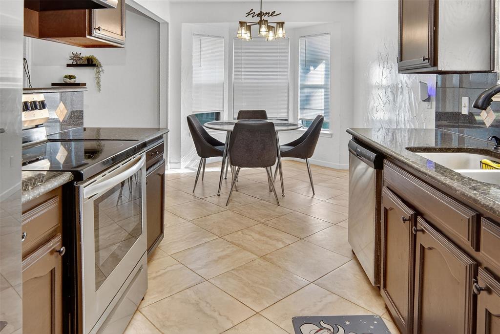 6004 Old Mill Court Watauga, TX 76148 - Photo 11 of 26 a kitchen with granite countertop a sink a counter space and stainless steel appliances