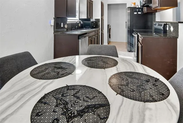 a kitchen with stainless steel appliances kitchen island a stove a table and chairs