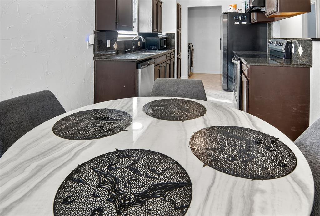 6004 Old Mill Court Watauga, TX 76148 - Photo 13 of 26 a kitchen with stainless steel appliances kitchen island a stove a table and chairs