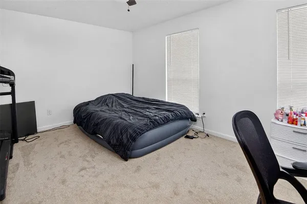 a bedroom with a bed chair and a potted plant